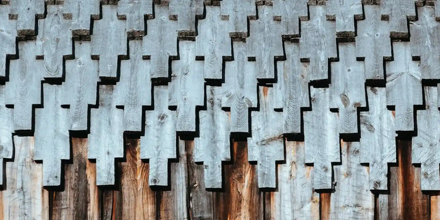 Close-up view of overlapping asphalt shingles on a roof, showing the interlocking pattern.
