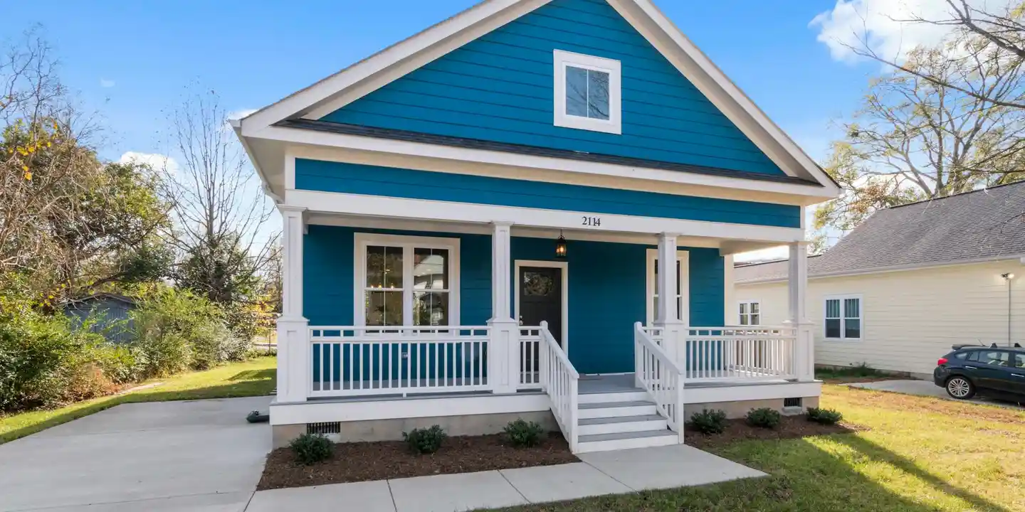 Front view of a blue house with a white front porch, steps, and railing.