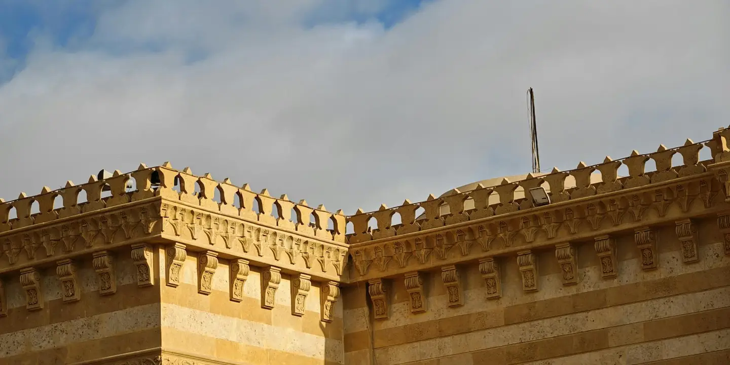 Castle-style stone wall with crenellations under a partly cloudy sky, representing construction decisions and budgeting for roof repairs.