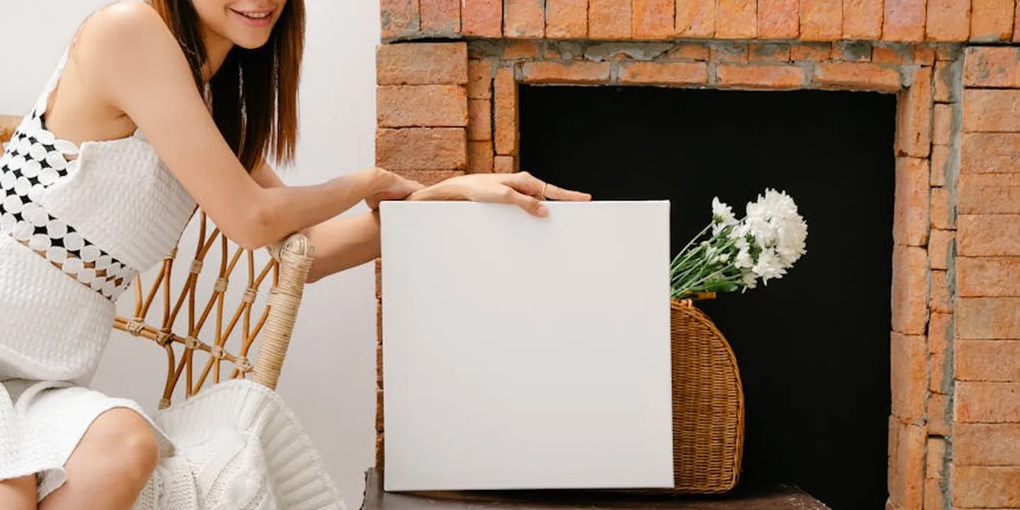 Person placing a blank white card near a brick fireplace indoors