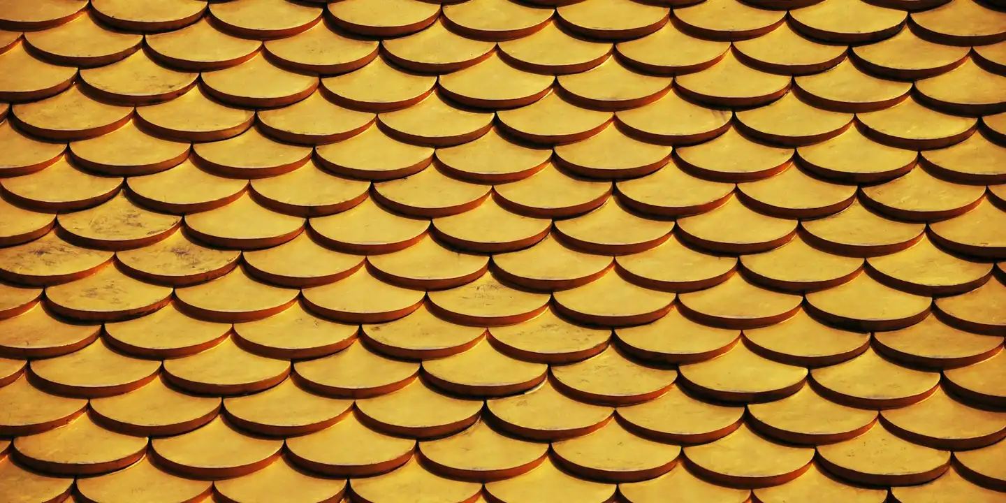 Close-up view of overlapping orange and gold roof shingles forming a repeating curved pattern