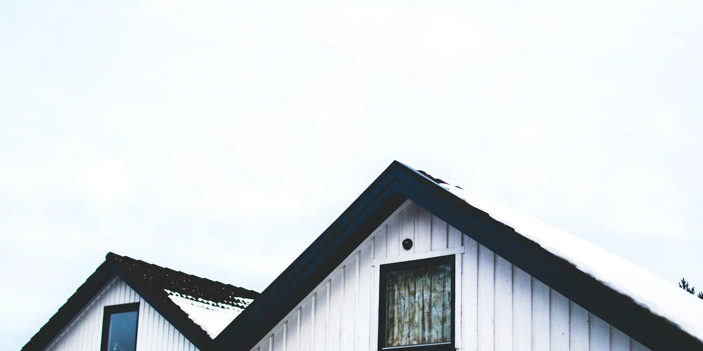 Snow-covered residential roof seen from the ground.
