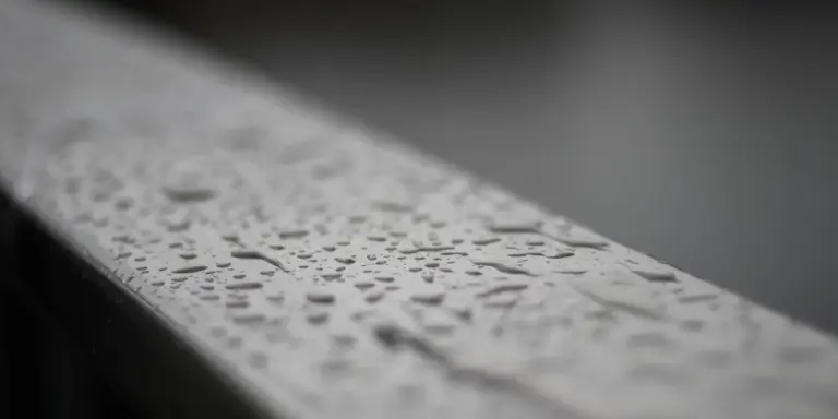 Close-up photo of a gutter edge with raindrops