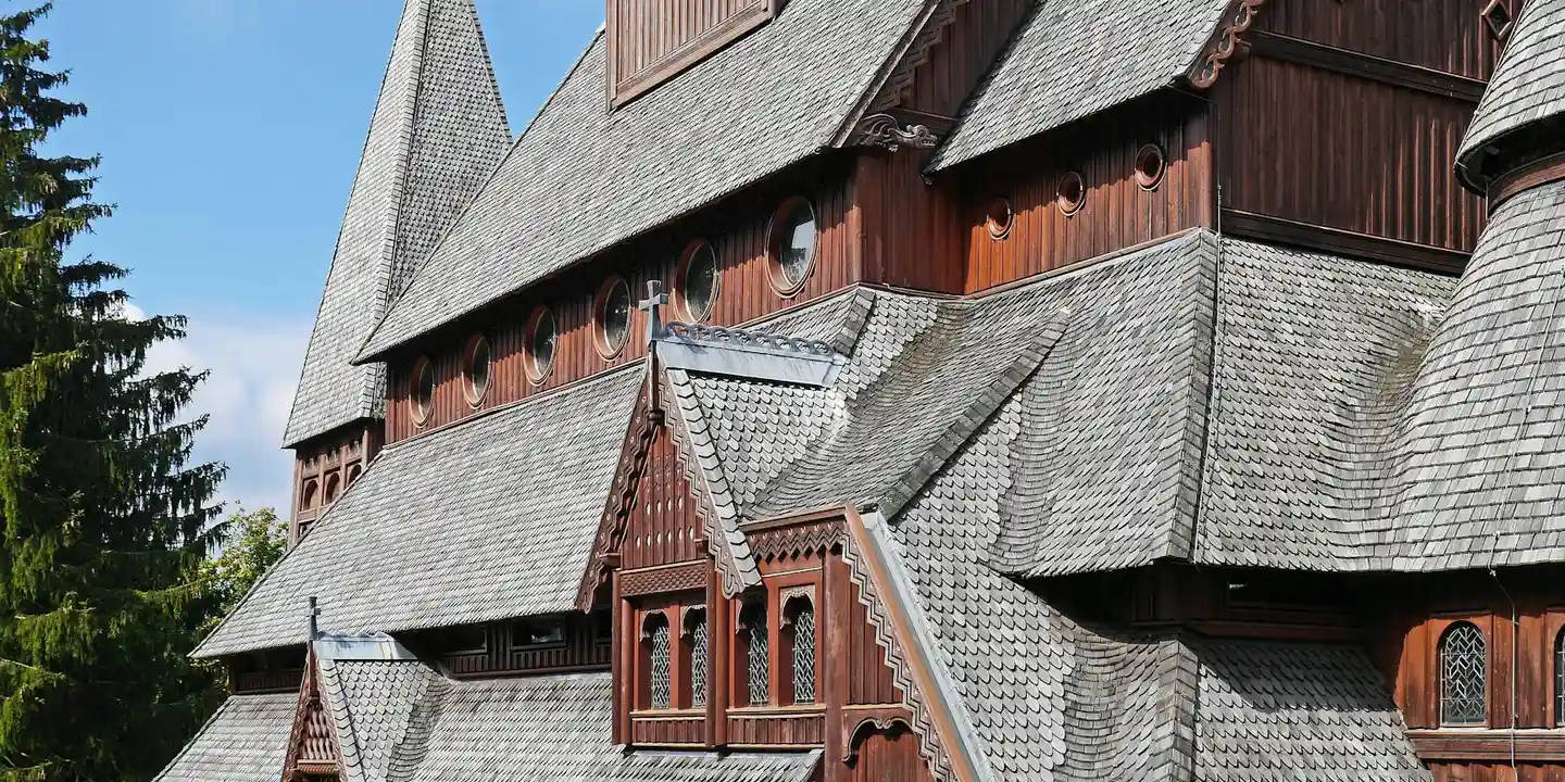 Traditional wooden roof with multiple steep tiers and overlapping shingles, showing complex roof geometry.