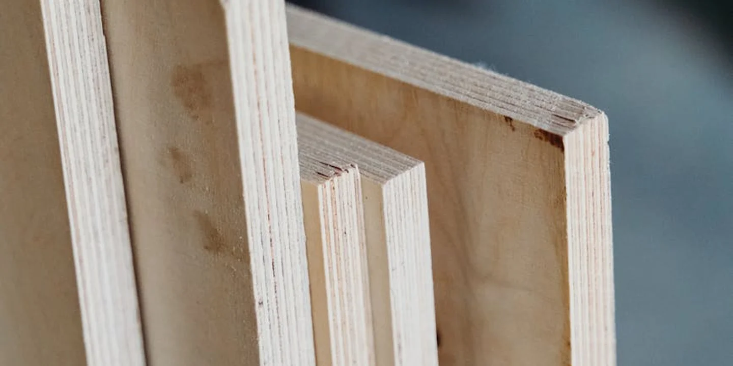 Close-up of unfinished pine framing for a porch roof, with vertical studs forming a square frame.
