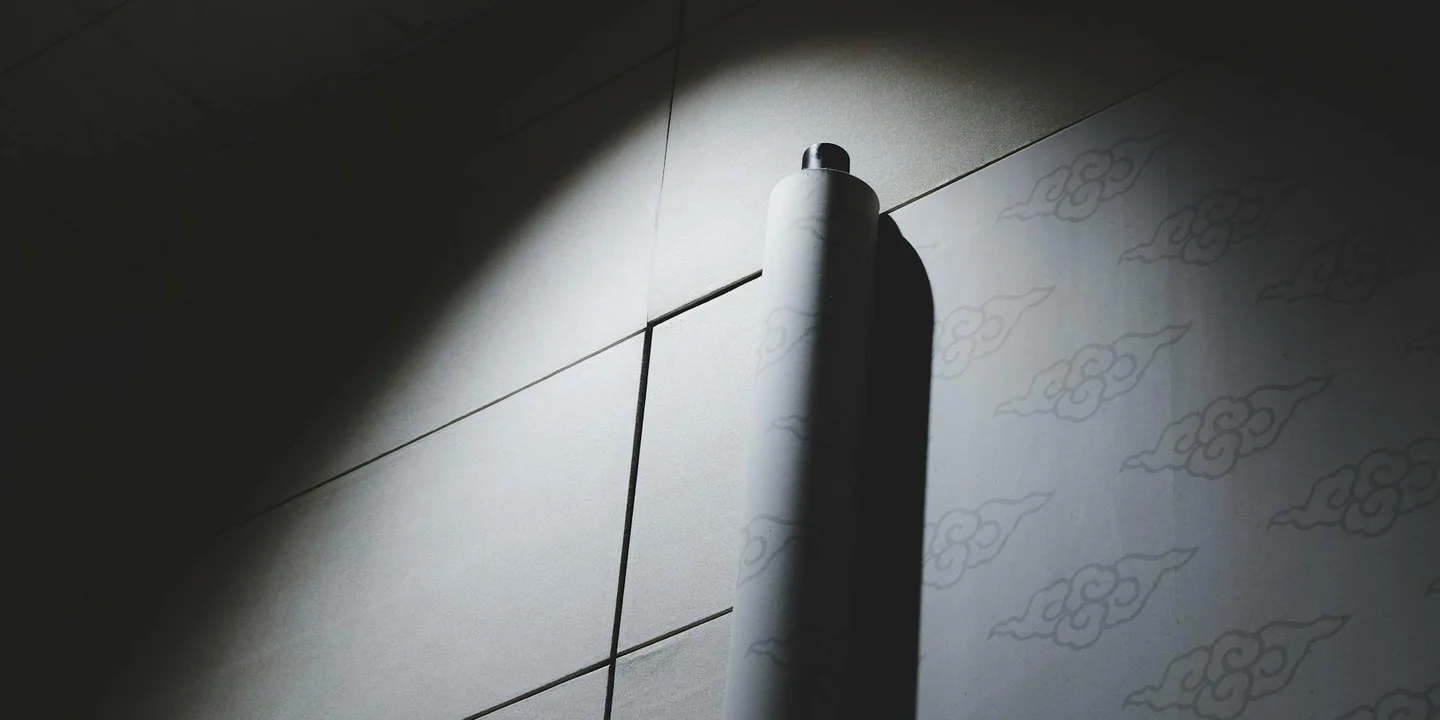 Close-up of a roll of peel-and-stick roofing material on a roof surface, with light and shadows highlighting where valleys, flashings, and penetrations will be sealed.