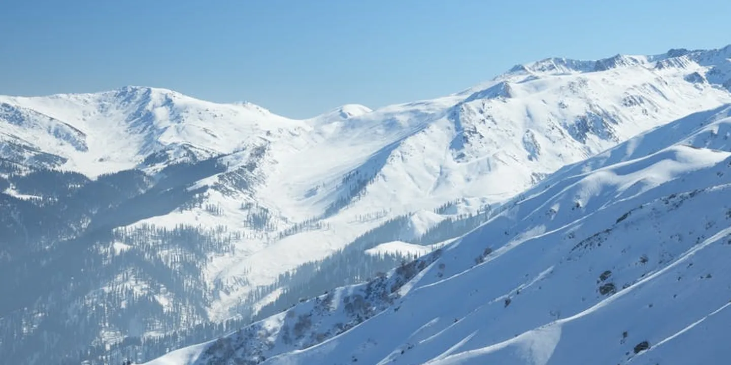 Snow-covered mountain ridge under a clear blue sky.