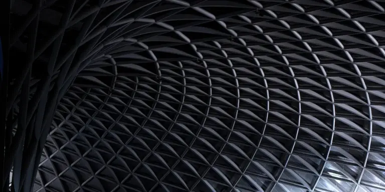 Close-up of curved roof truss ribs forming a geometric pattern.