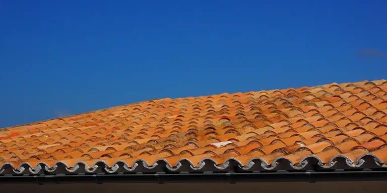 Orange clay tile roof under a clear blue sky