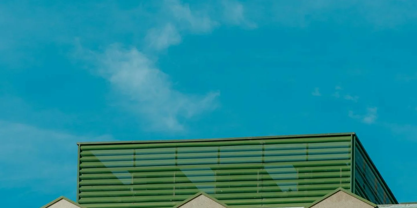 Blue sky above a pitched roof featuring a skylight window.
