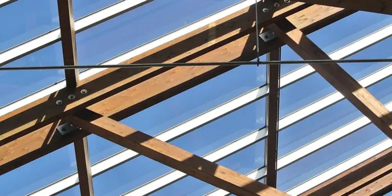 Timber roof framing with glass skylights, showing the components of roof window installation.