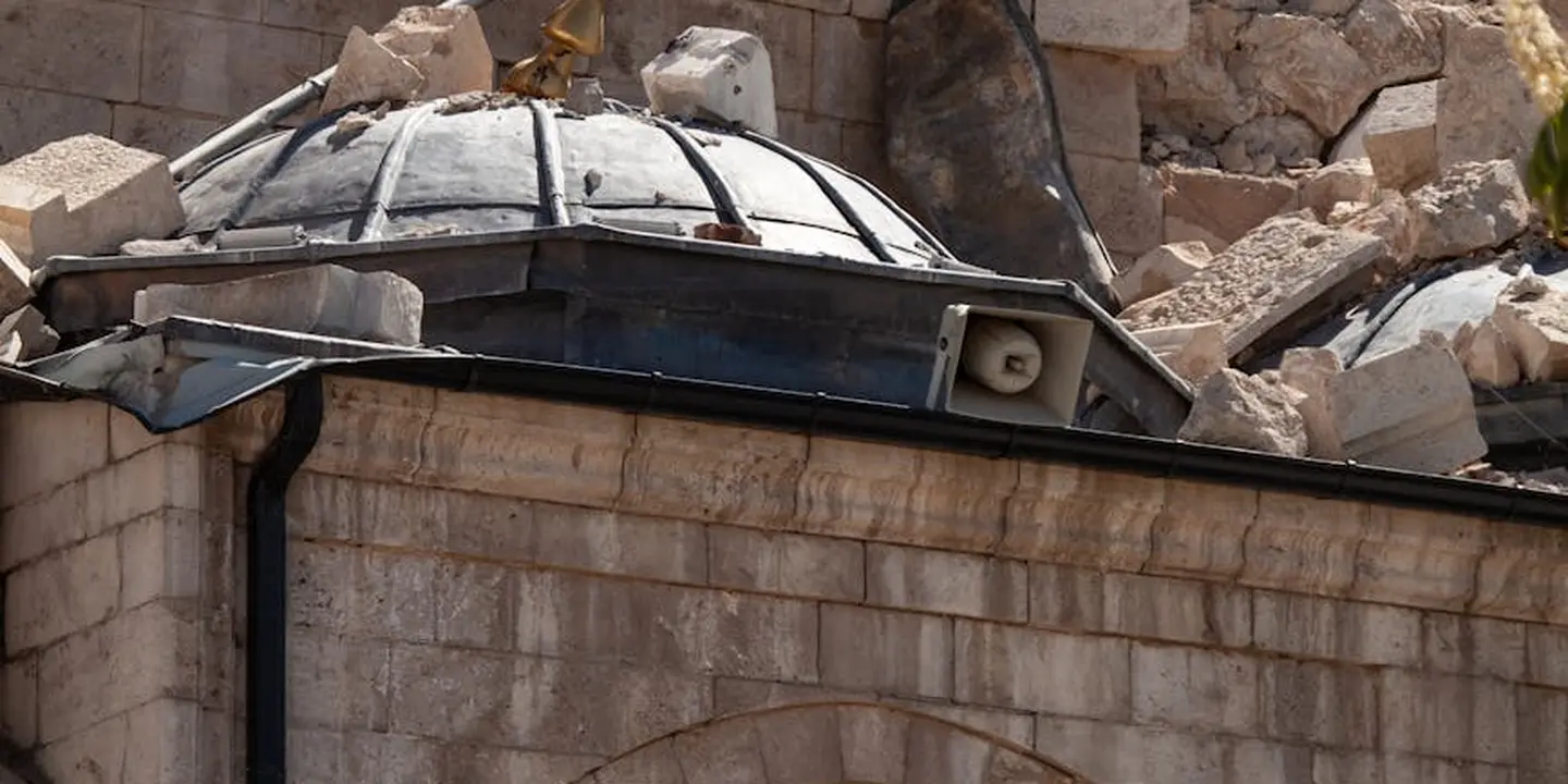 Roof heavily damaged with rubble and a cracked skylight; debris scattered across the roof surface.