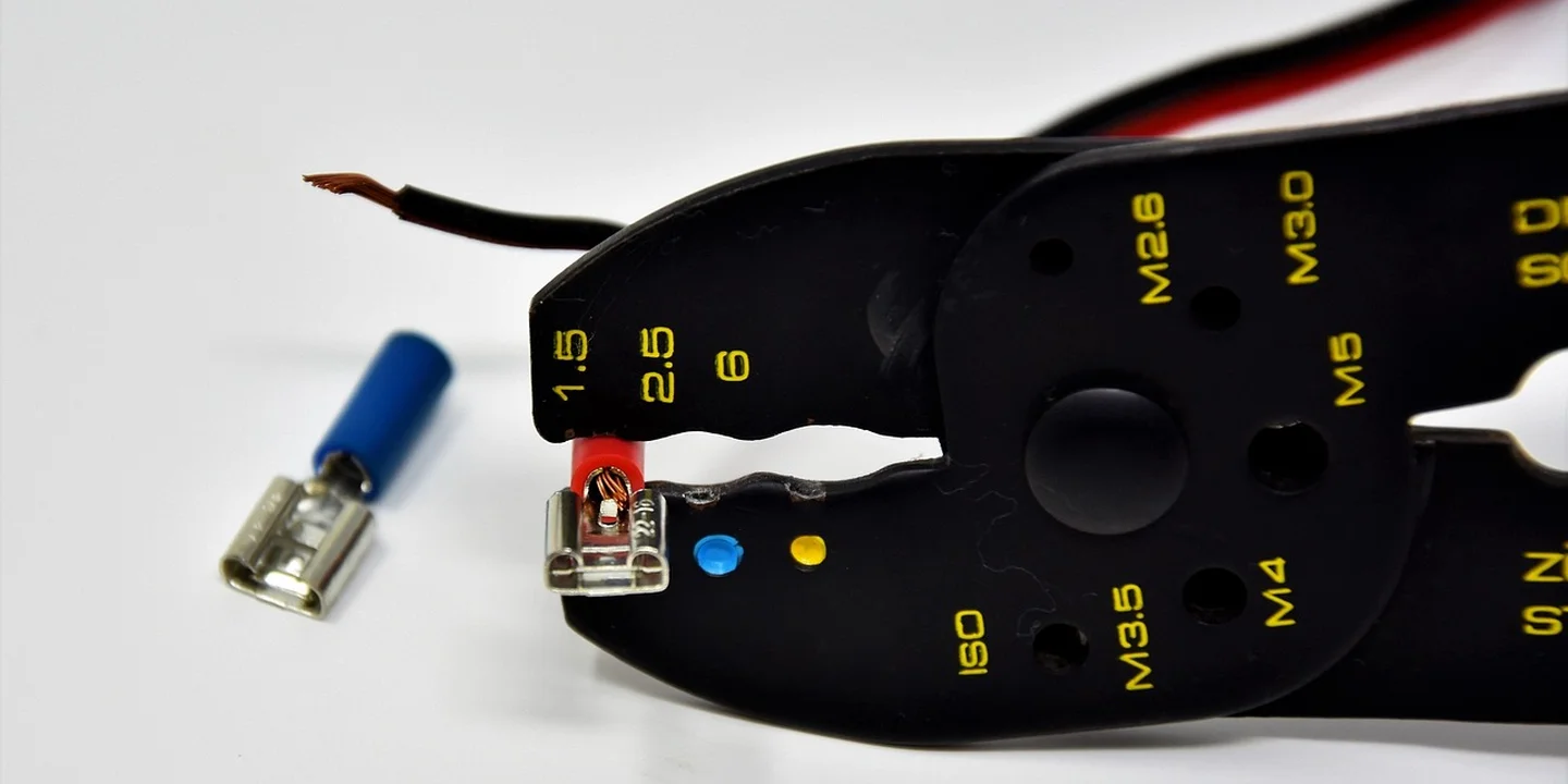 Close-up of roof heating cable installation hardware, showing connectors and mounting components on a curved black surface.