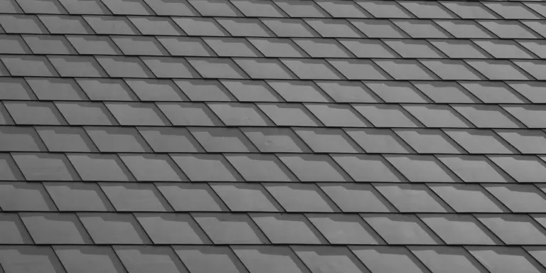 Close-up of a gray asphalt shingle roof with overlapping rectangular shingles.