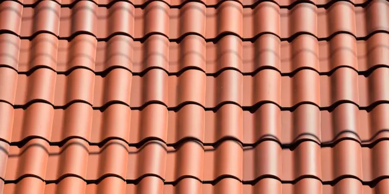 Close-up view of overlapping red clay roof tiles.