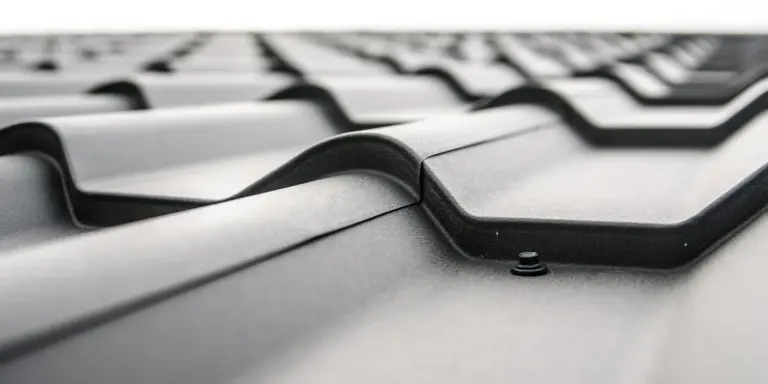 Close-up of metal roofing tiles with overlapping seams and visible fasteners.