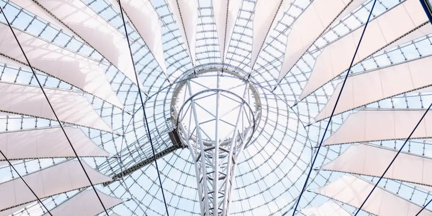 Interior view of a circular skylight with a metal supporting framework and glass panels set into a vaulted roof