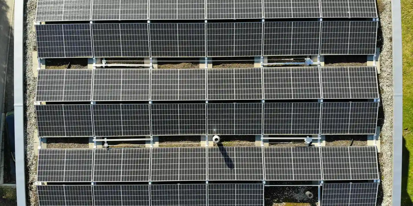 A top-down view of solar panels mounted on a sloped roof with metal racking.