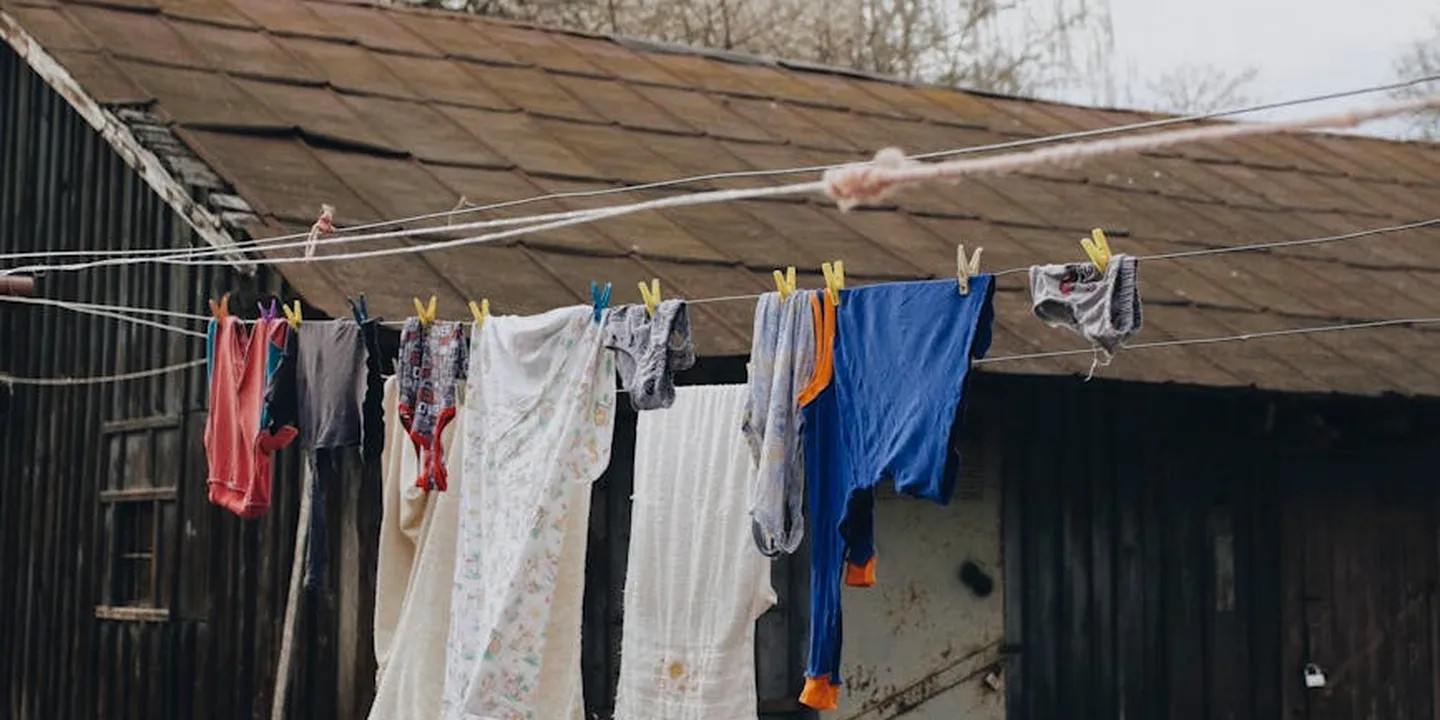 A small shed with a sloped roof and clothes hanging on a line across the front.