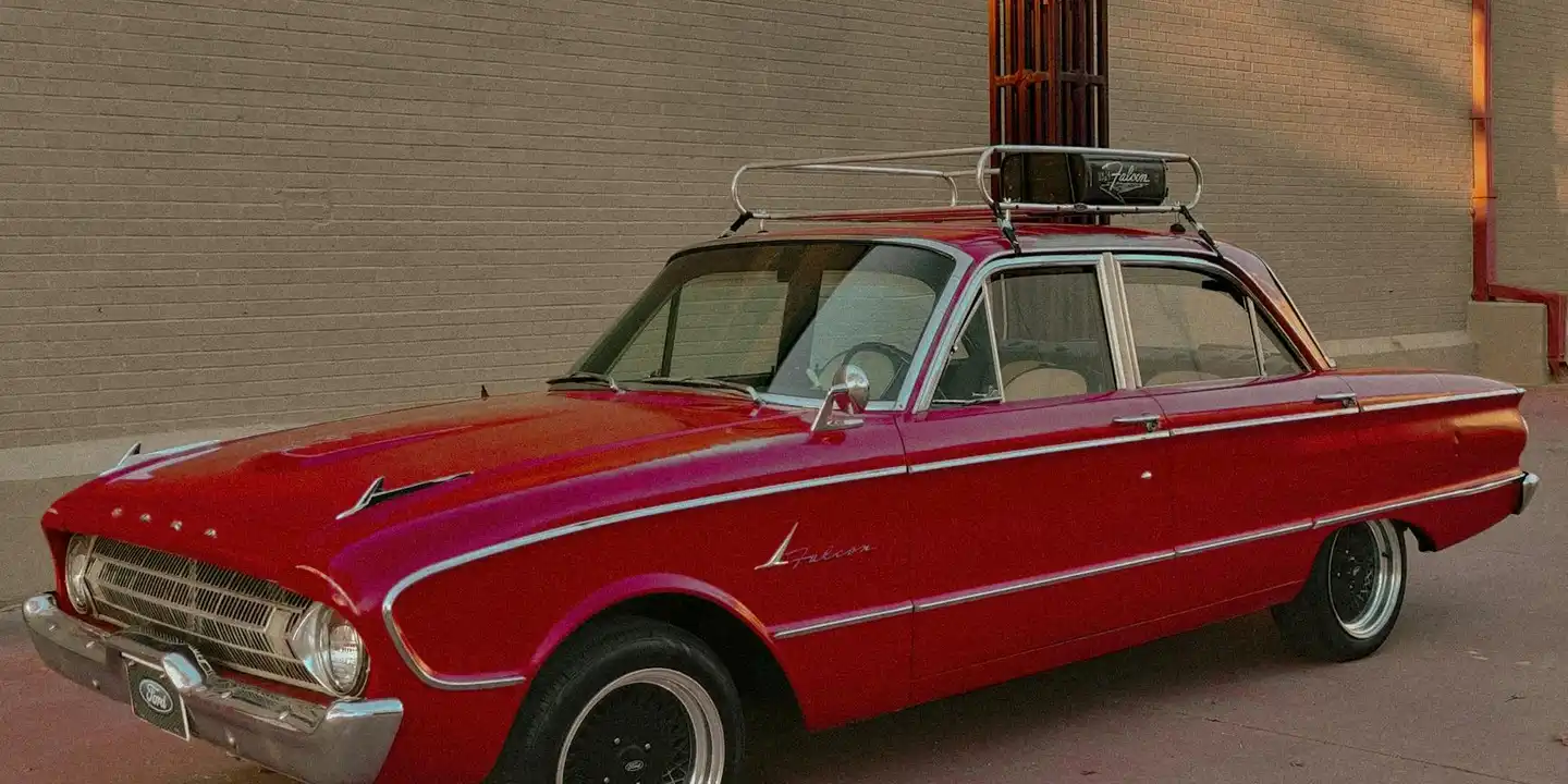 Red vintage car with a rooftop cargo rack