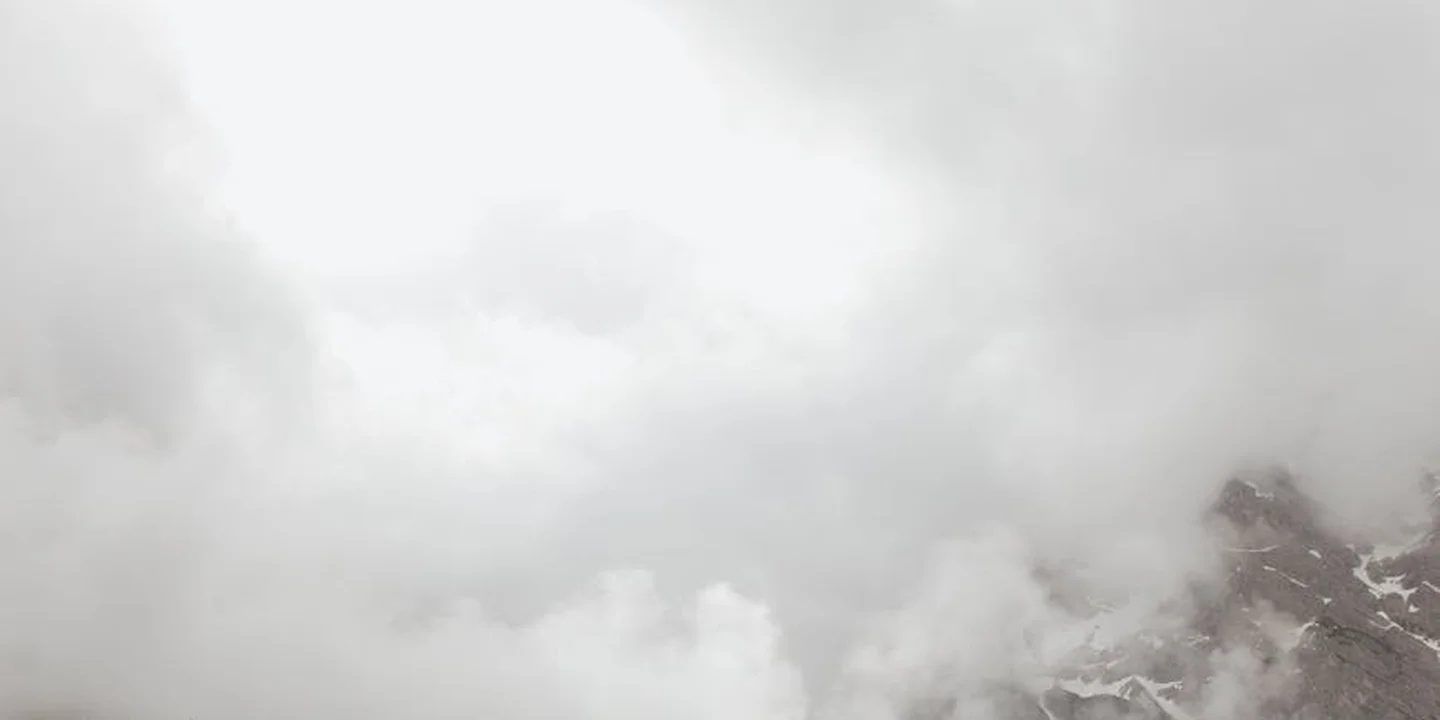 Overcast sky with clouds above a distant mountain range.