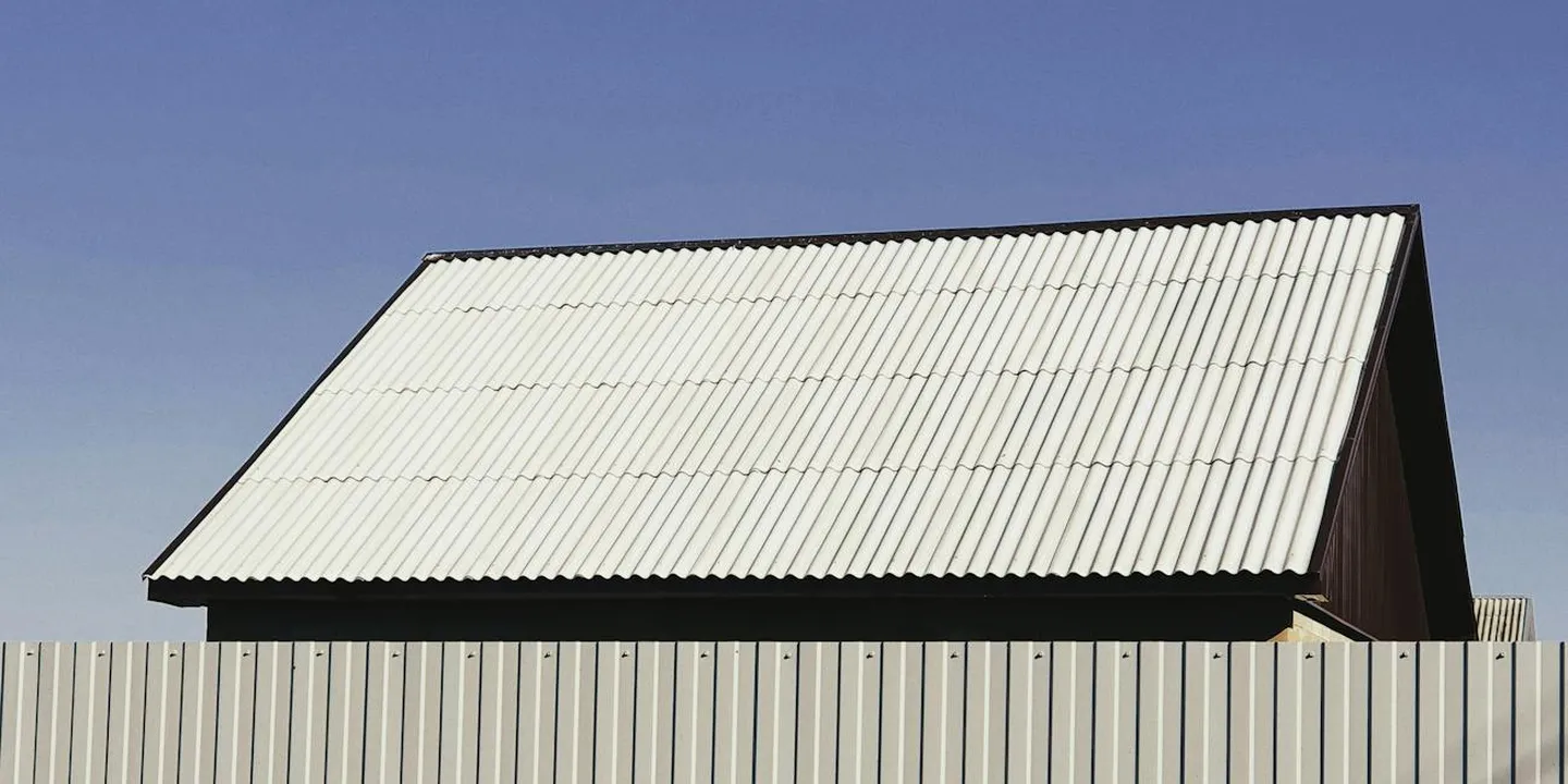 Corrugated metal roofing sheet on a small building with a clear blue sky