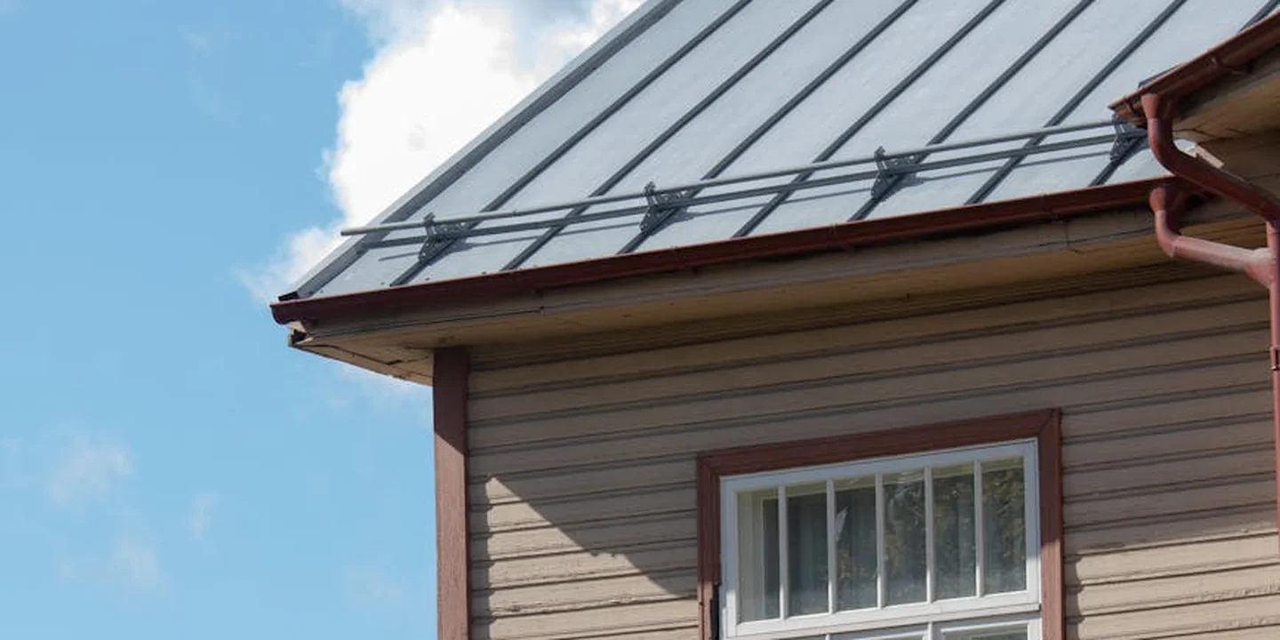 A metal roofing on a house with standing seam panels, showing sheet material used for the roof