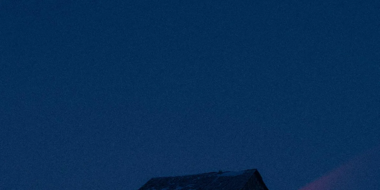 Close-up of a dark blue metal roof panel against a clear blue sky.