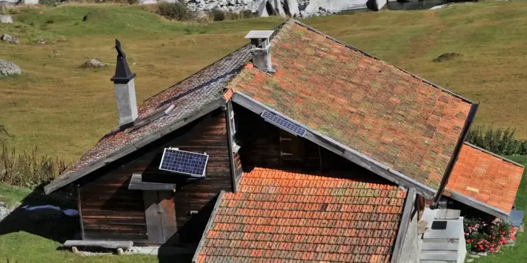 Rustic house with red-tiled roof and a small rooftop solar panel.