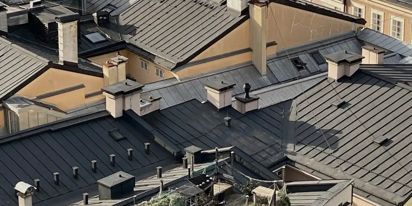 Aerial view of gray metal rooftops covering a cluster of residential buildings.