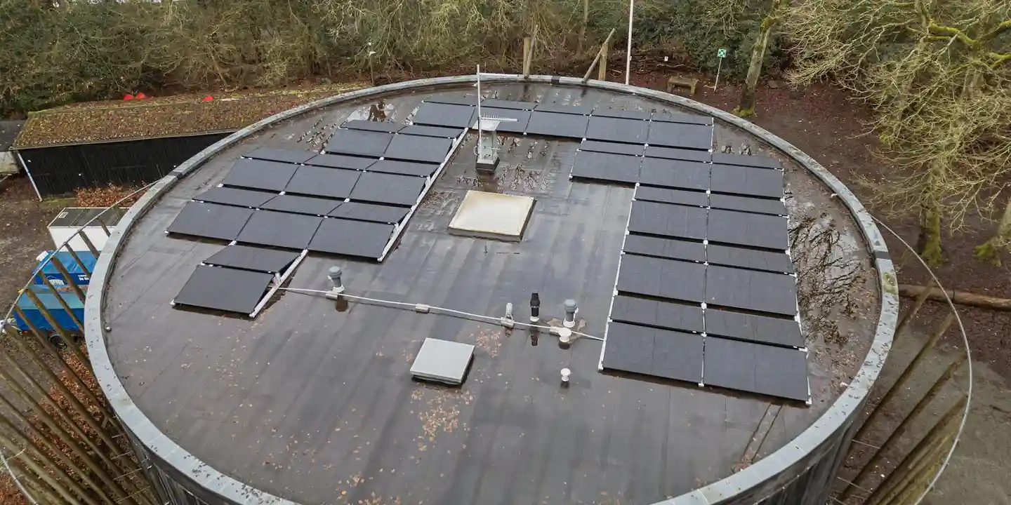 Circular roof with a dark surface and installed solar panels, illustrating a complex roof plane that requires careful planning.